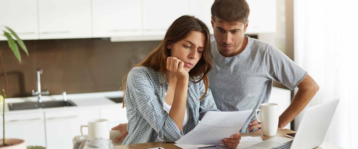 Picture of young wife and husband in kitchen looking for a mortgage refinance