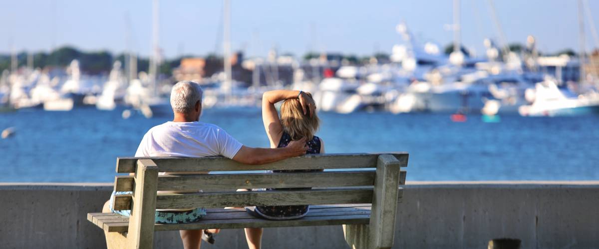 Older couple sitting on bend overlooking water