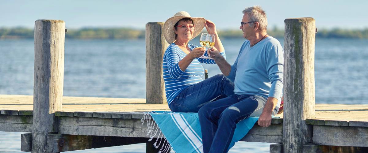 Older couple sitting on a boardwalk