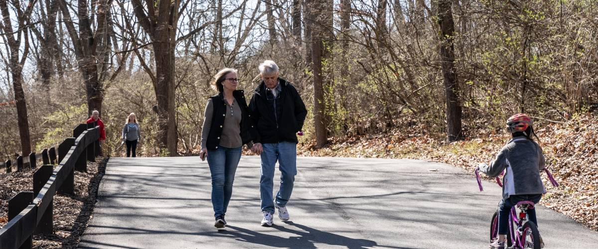 Older couple walking through a park
