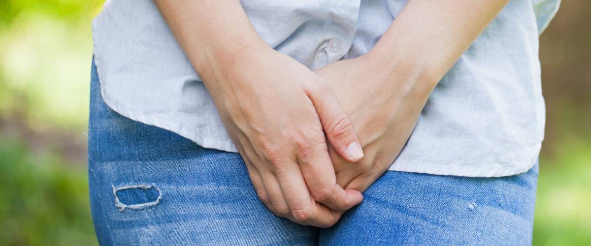 Close up picture of a woman holding her crotch, she needs to pee immediately, outdoor
