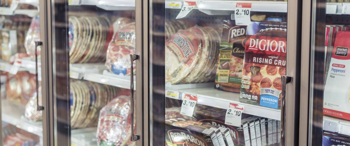 Moorhead, Minnesota, United States - December 7, 2015: Freezer full of pizza in local supermarket, seen through the glass.