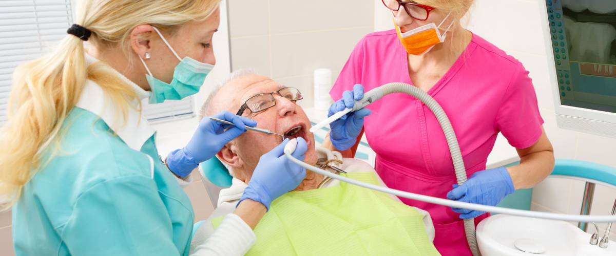 Old Senior man at dentist surgery having tooth operation in stomatology clinic