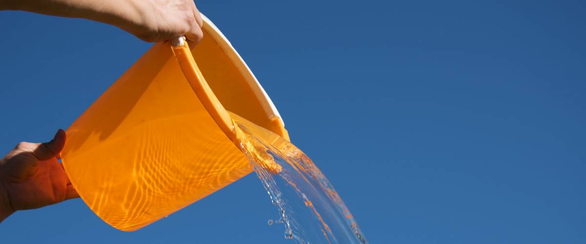 Pouring water against blue sky.