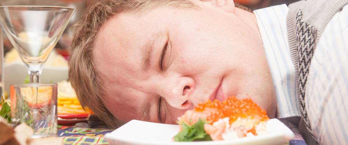 Caucasian drunk man resting head on table