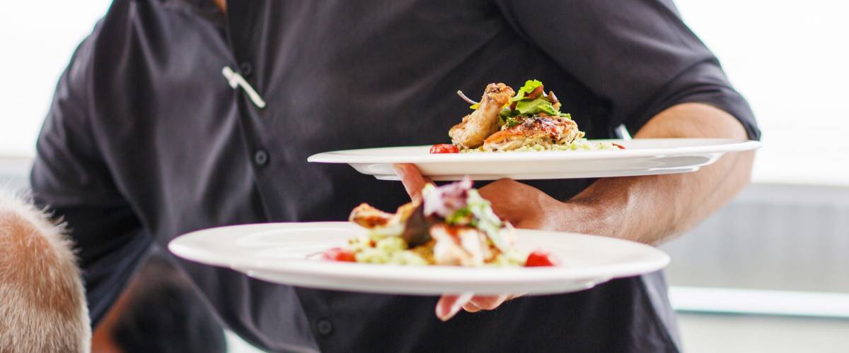 Waiter carrying a plate with salad dish on a wedding