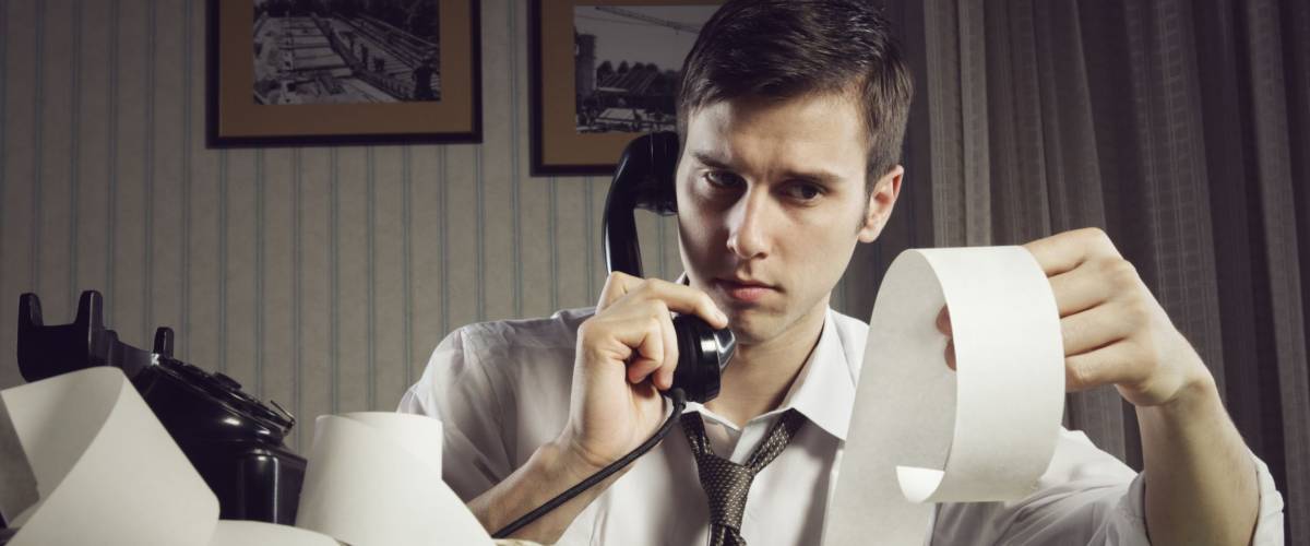 An male accountant at telephone preparing income taxes