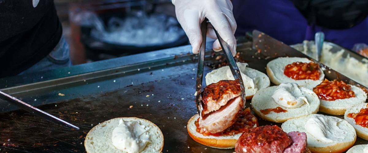 Cook making burgers outdoor on street food festival event