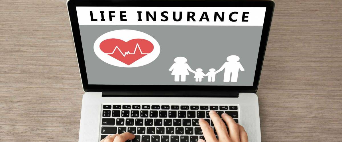Man using laptop at wooden table. Life insurance concept