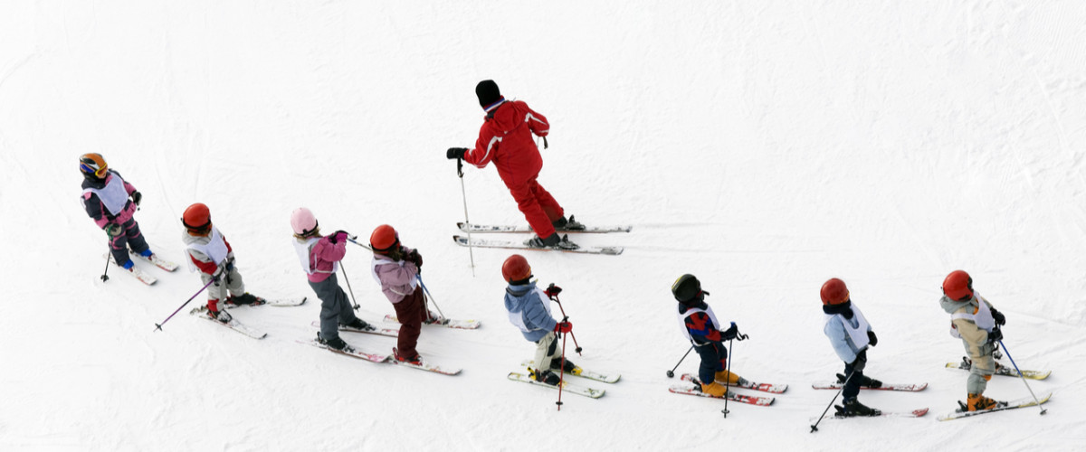 Skiing lessons students and their teacher
