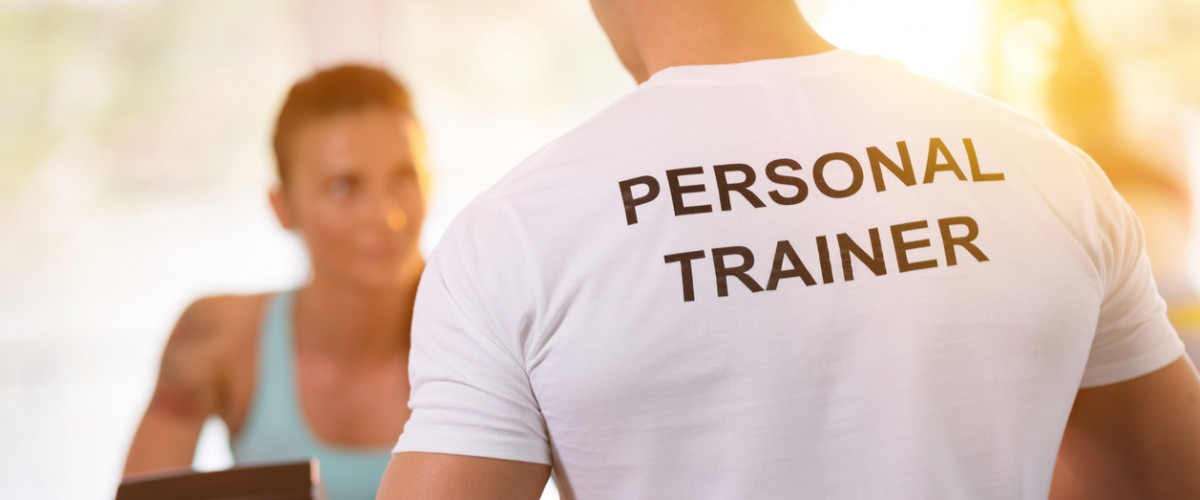 Personal trainer with his female client at the gym