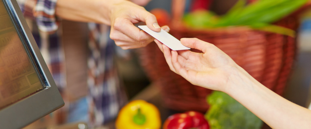 Handing a card to cashier at the grocery store