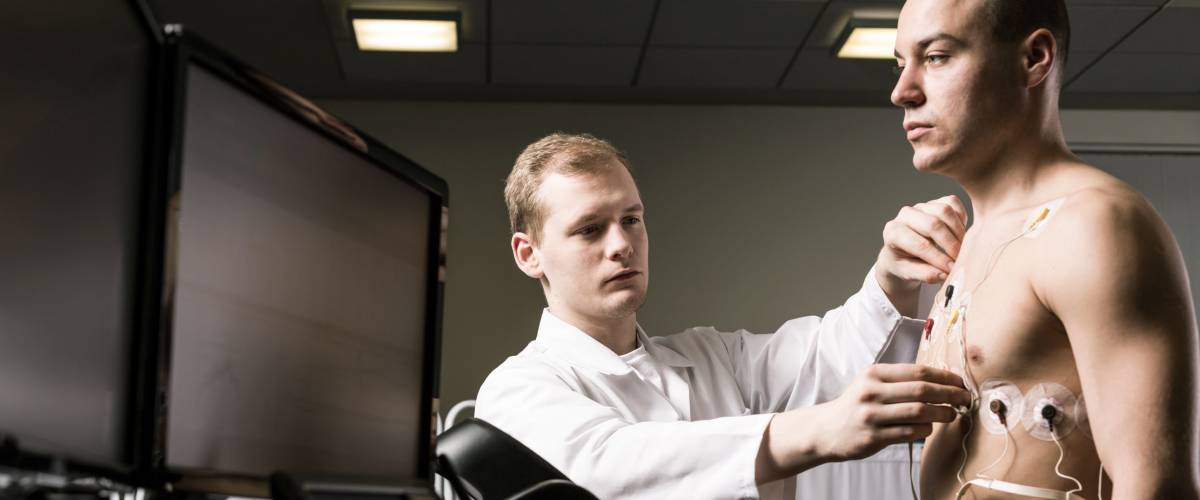 Doctor is preparing a sportsman to the medical trial