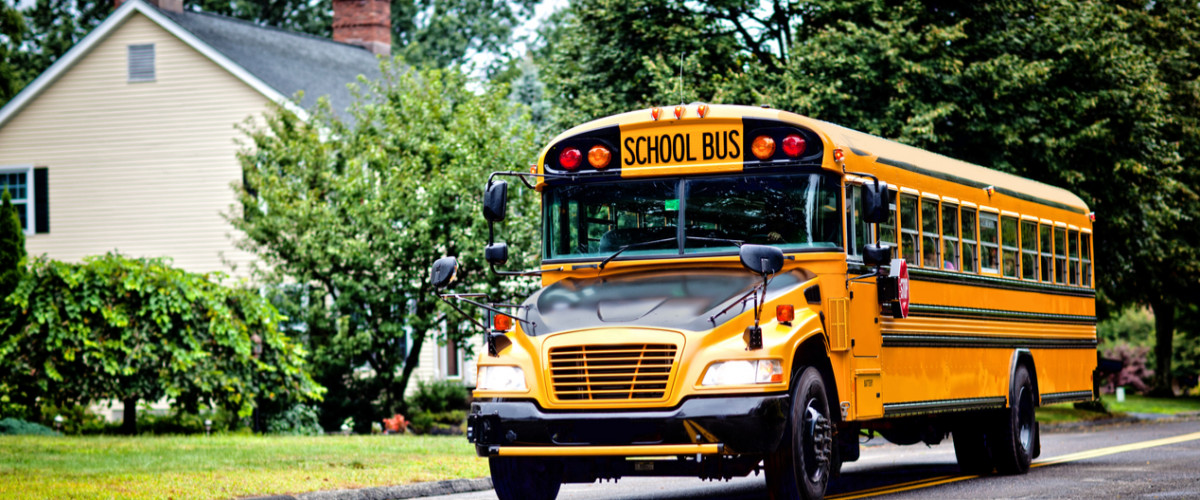 Yellow school bus driving down the street
