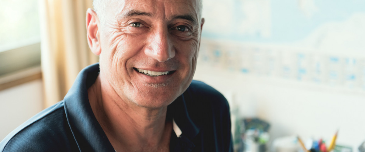 Adult middle aged man working from home office smiling at camera very happy and relaxed