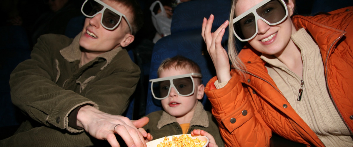 Happy young family at movie theatre