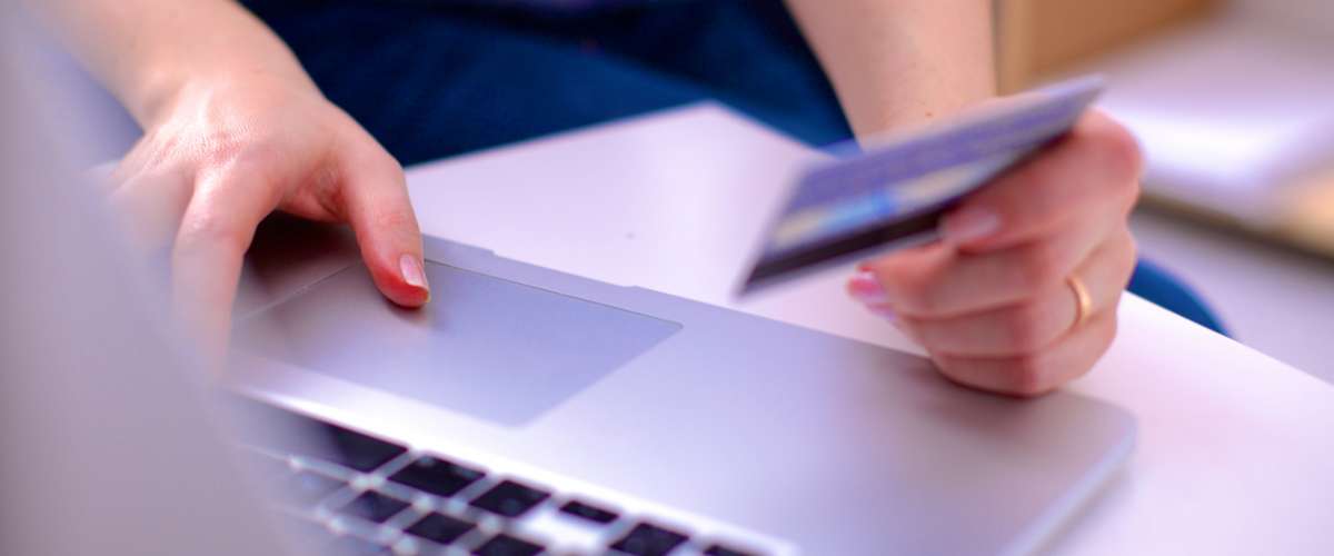 Hands holding a credit card and using laptop computer for online shopping
