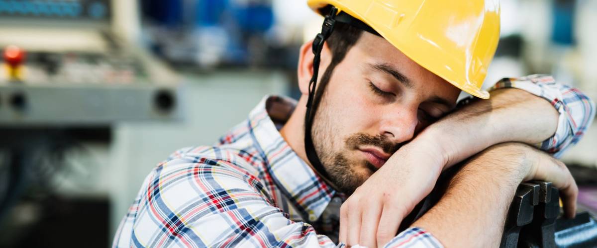 Tired worker fall asleep during working hours in factory