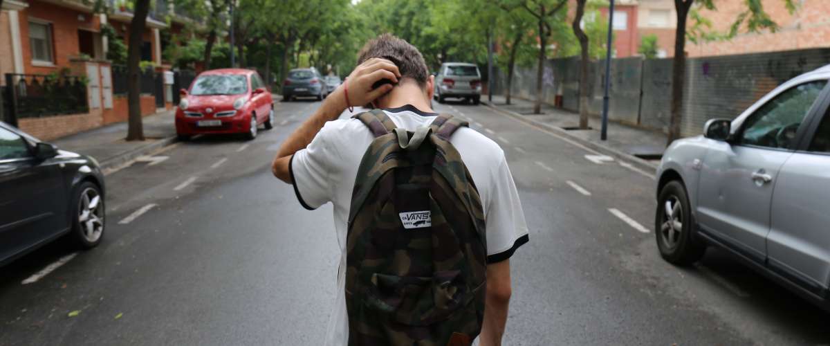 Teenage boy walking down the middle of a street urban
