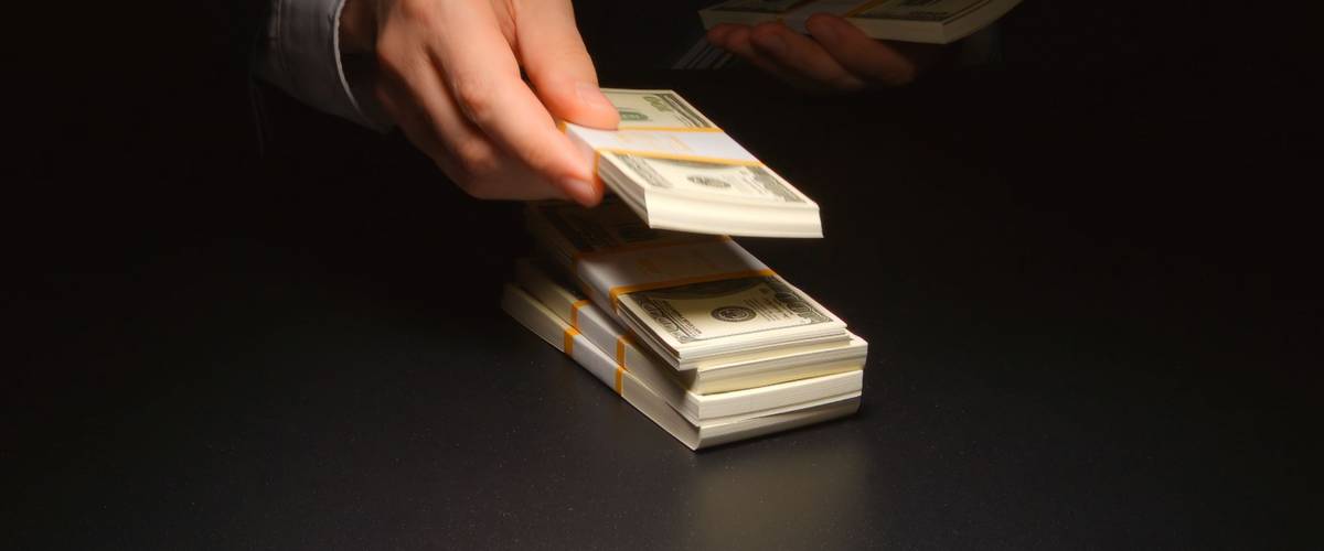 BRIBE: Businessman counts and puts down a heap money on a table