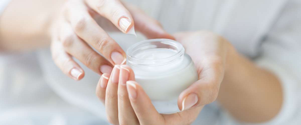 Closeup shot of hands applying moisturizer