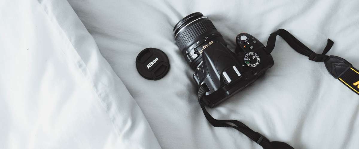 DSLR camera on white bed sheets