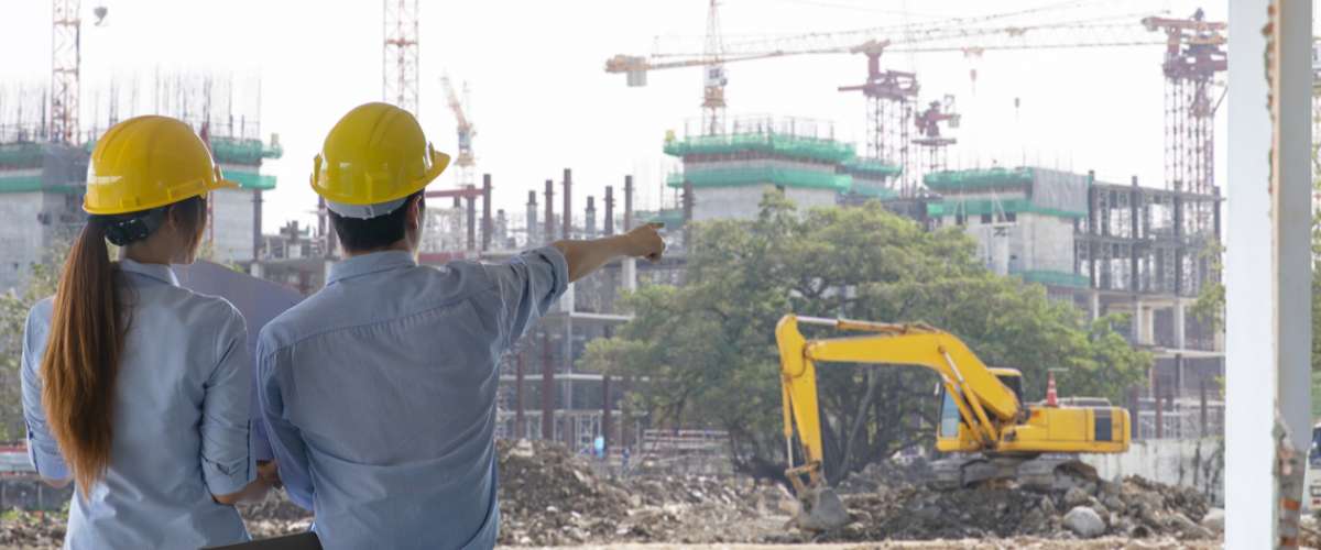Engineer group and worker meeting, discussion with construction blueprint on site work and point finger to the work site