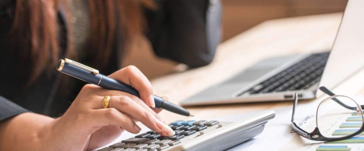 Close up of female accountant or banker making calculations. Savings, finances and economy concept