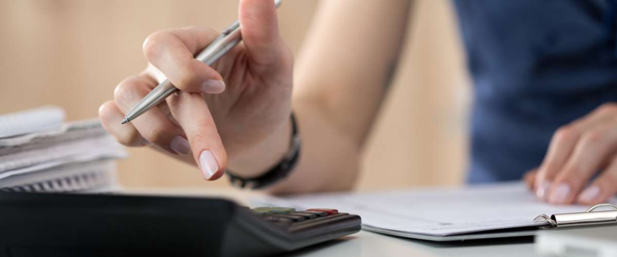 Close up of female accountant or banker making calculations. Savings, finances and economy concept