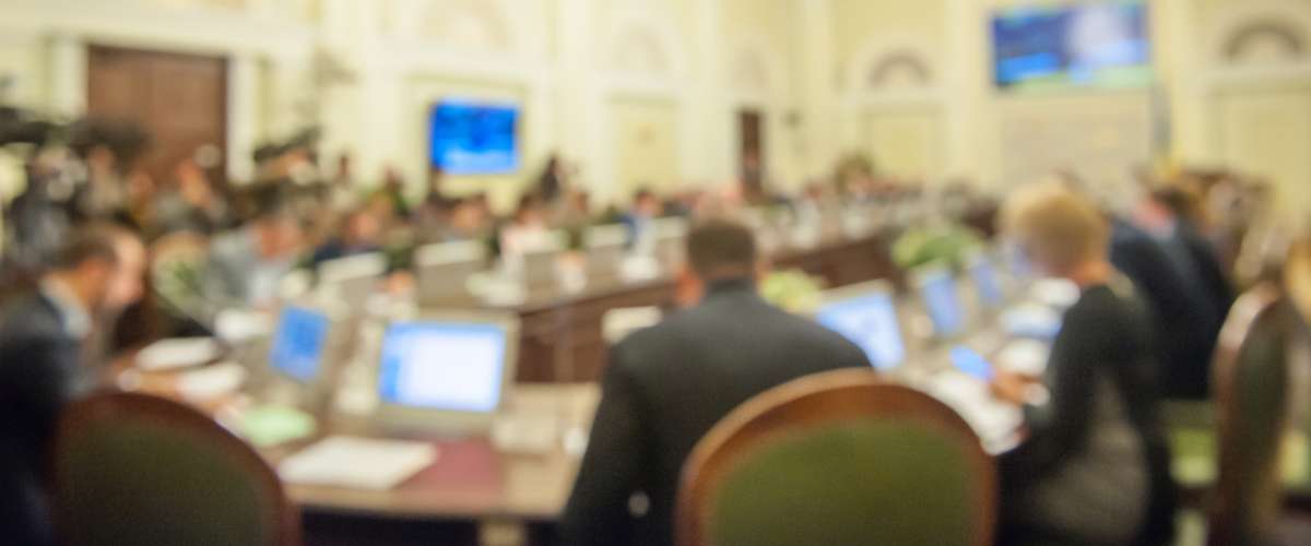 conference with many people in suits in a hotel conference room
