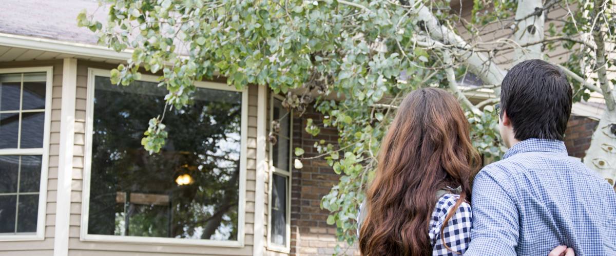homeowner couple outside new home purchase