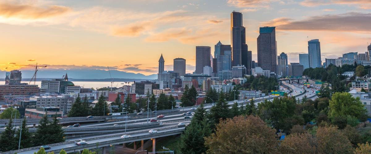 Seattle skylines and Interstate freeways converge with Elliott Bay and the waterfront background of in sunset time, Seattle, Washington State, USA.