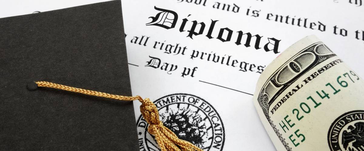 graduation cap and money on a diploma