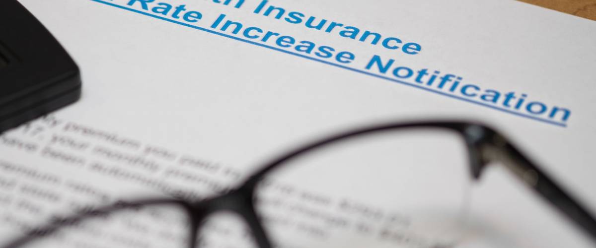 NOTICE OF INCREASING IN PREMIUM RATE OF HEALTH INSURANCE WITH A PAIR OF GLASSES AND A CALCULATOR