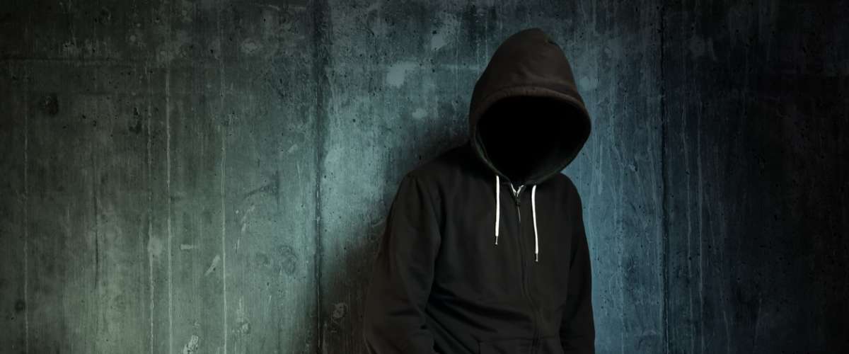 hidden figure wearing a hoodie in the dark