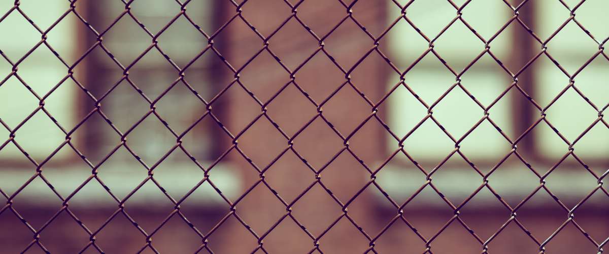 school building as seen through fence
