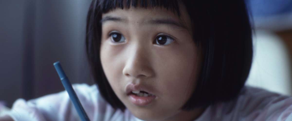 young girl holding a pen learning in school class
