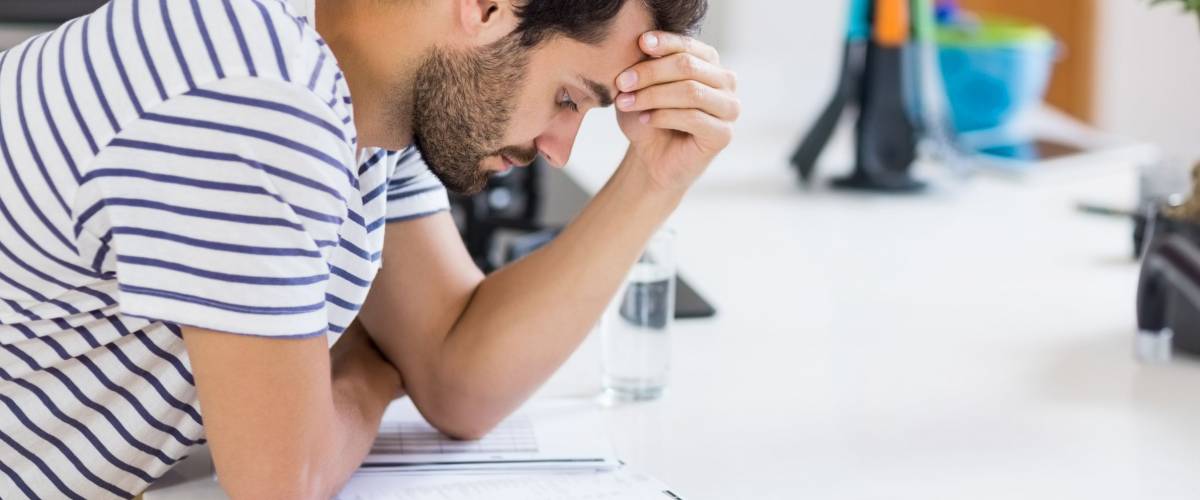 Worried man looking at bills in the kitchen