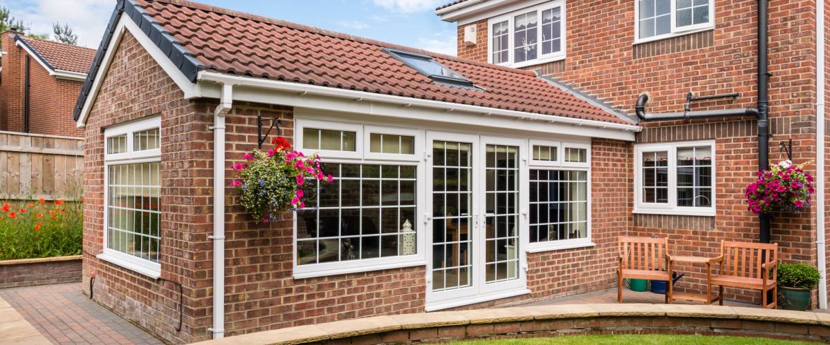 Modern Sunroom external / Modern Sunroom or conservatory extending into the garden, surrounded by a block paved patio