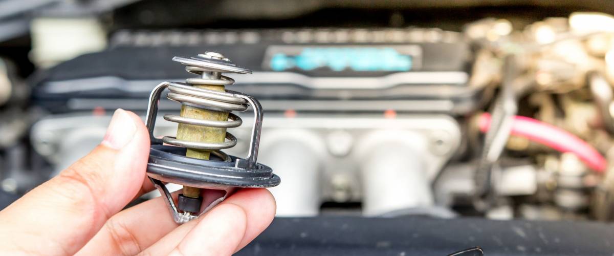 Hand a man put car thermostat for service