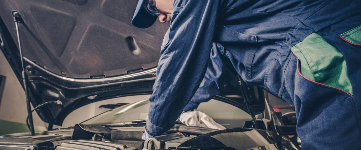 Auto Service Business Concept. Pro Car Mechanic Taking Care of Vehicle. Checking Under the Car Hood.