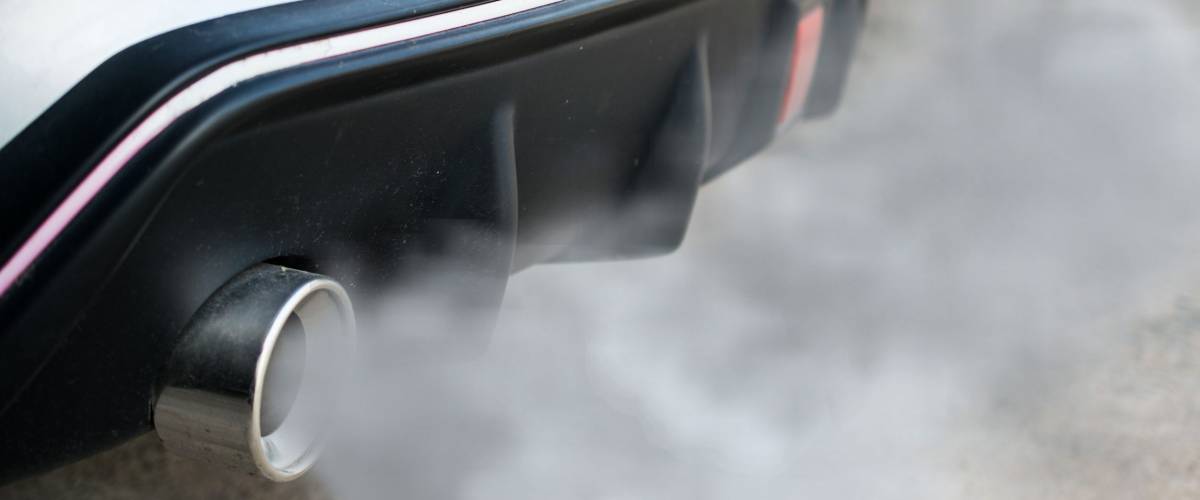 combustion fumes coming out of car exhaust pipe