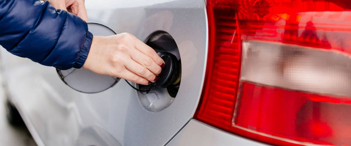 Woman opening fuel filler at the gasoline station