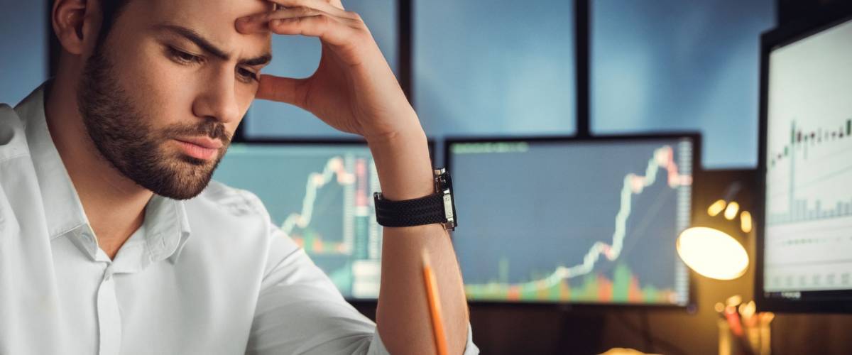 Serious businessman thinking hard of problem solution working late in office with computers