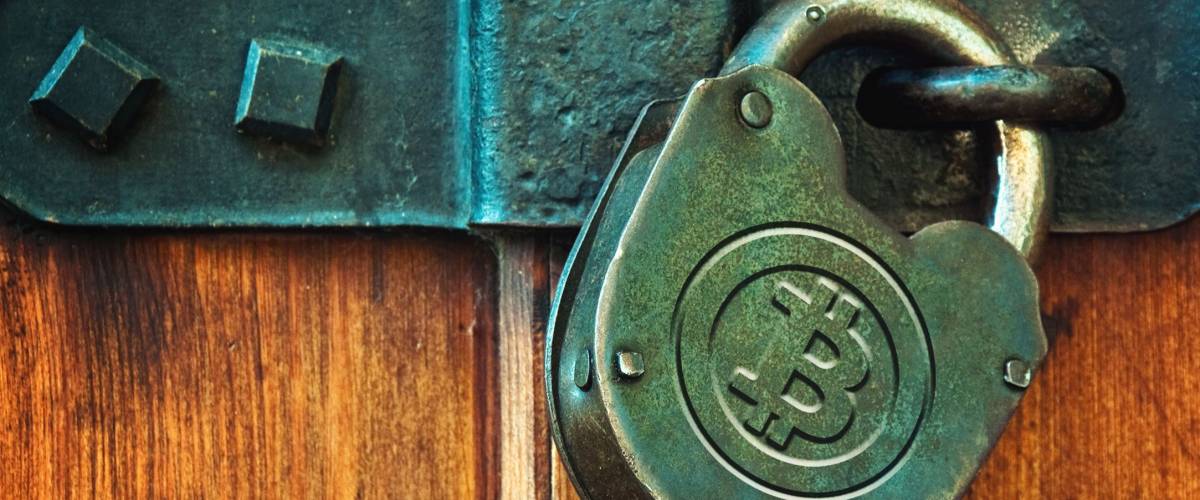 Bitcoin currency symbol on old metal padlock, safety concept.