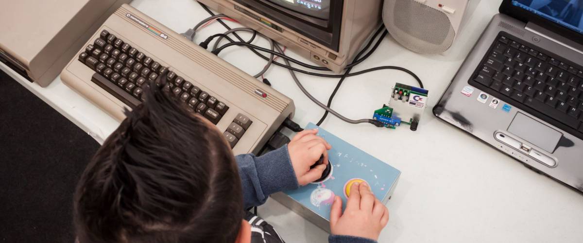 MILAN, ITALY - MARCH 30: Kid plays vintage video games at Robot and Makers Milano Show, event dedicated to robotics and makers on MARCH 30, 2014 in Milan.