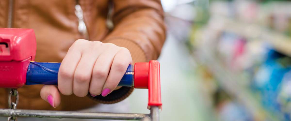 close up on hand of a woman on a supermarket trolley carries