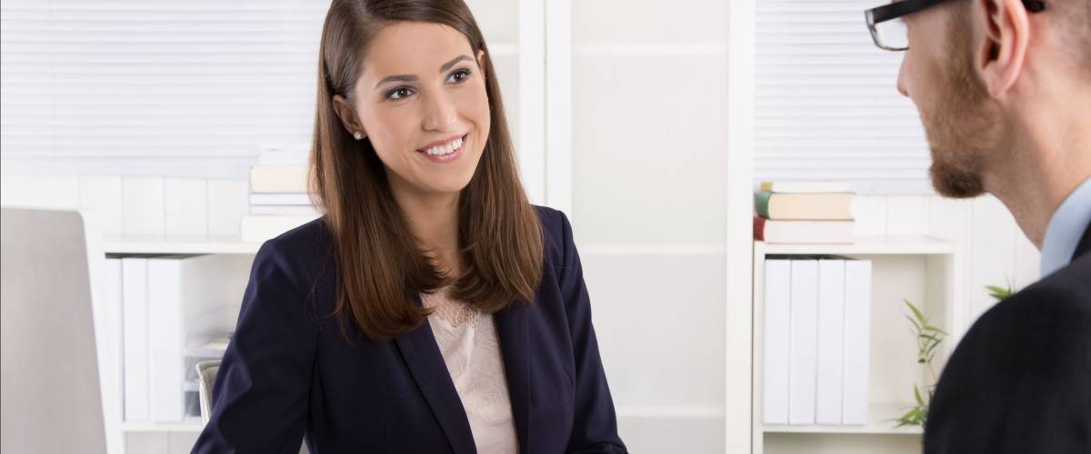 Customer and female financial agent in a discussion at desk.