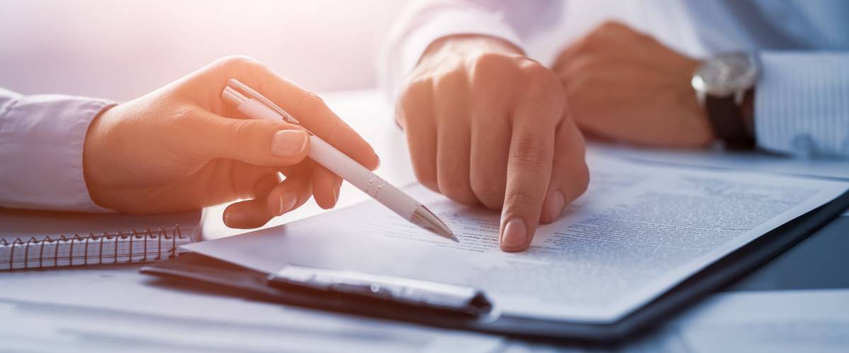 Business people negotiating a contract. Human hands working with documents at desk and signing contract.