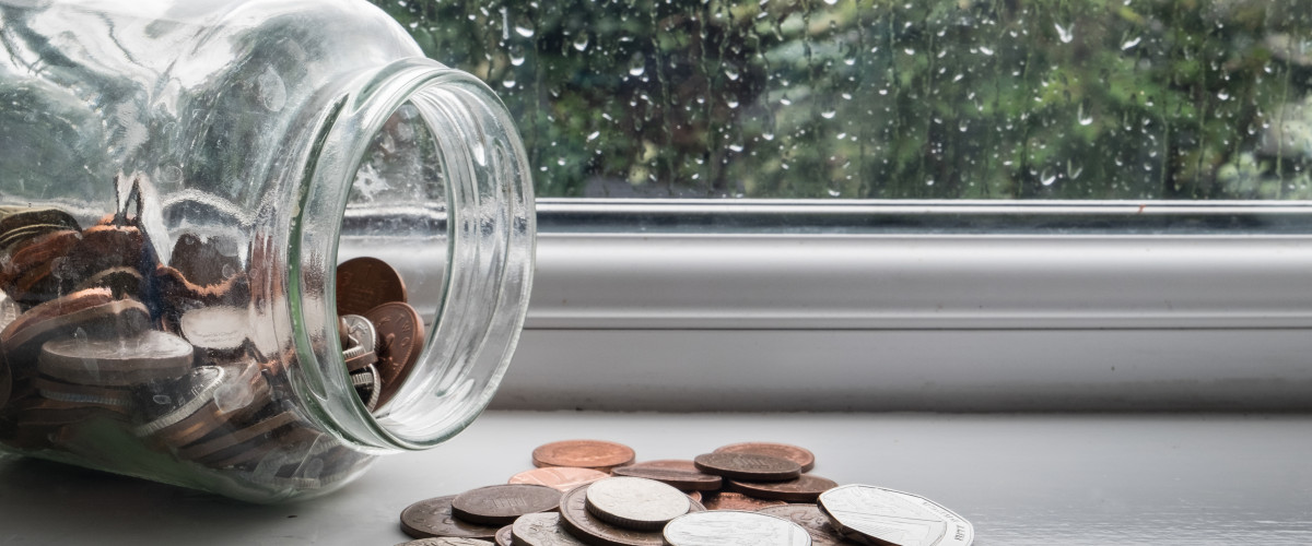 Jar of english money with rainy day background